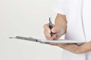 整骨院が初めての方が初診の問診票を記入している様子
